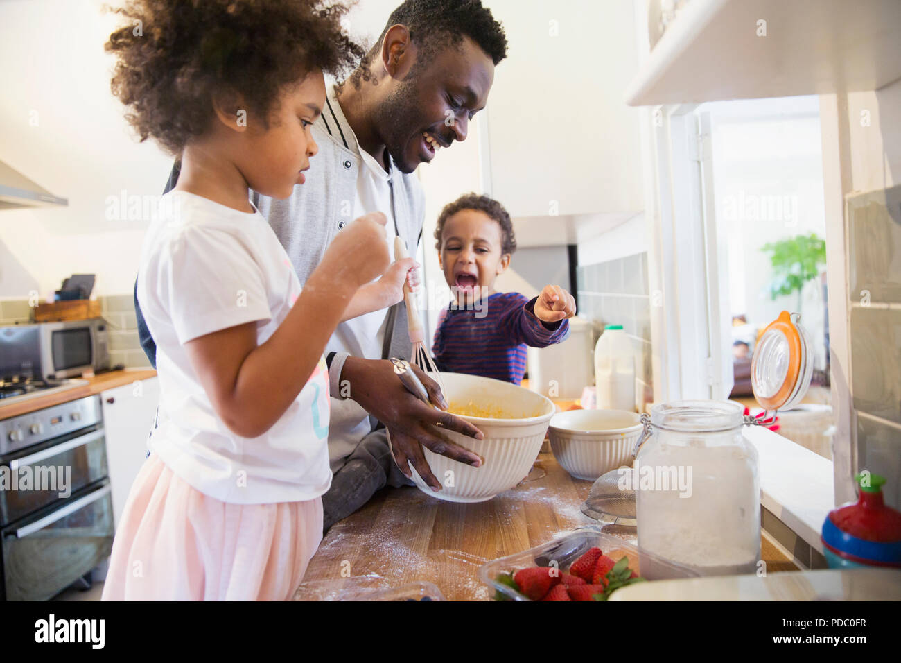 Father and toddler children baking in kitchen Stock Photo
