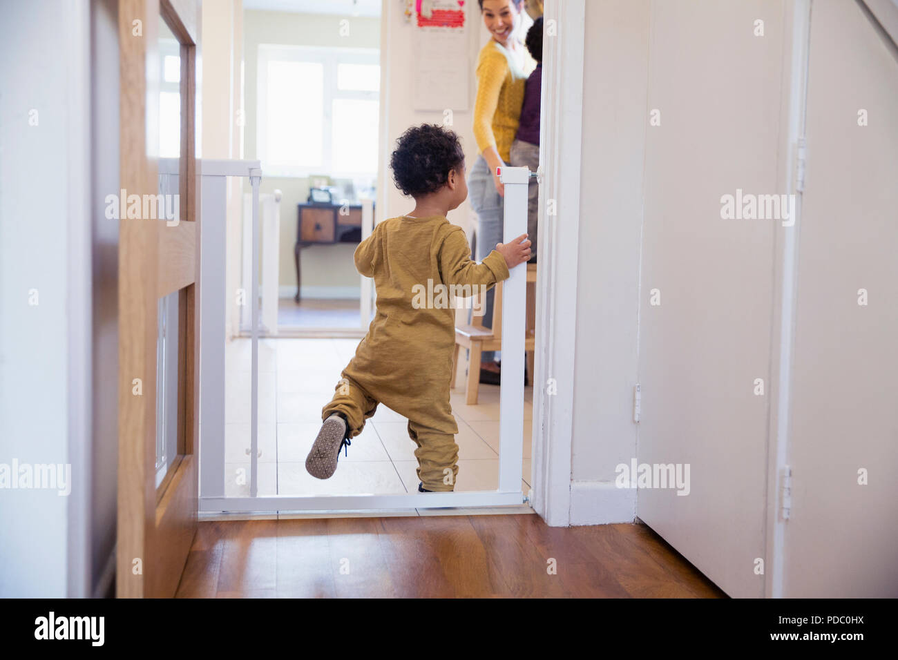 Cute baby boy balancing in doorway Stock Photo