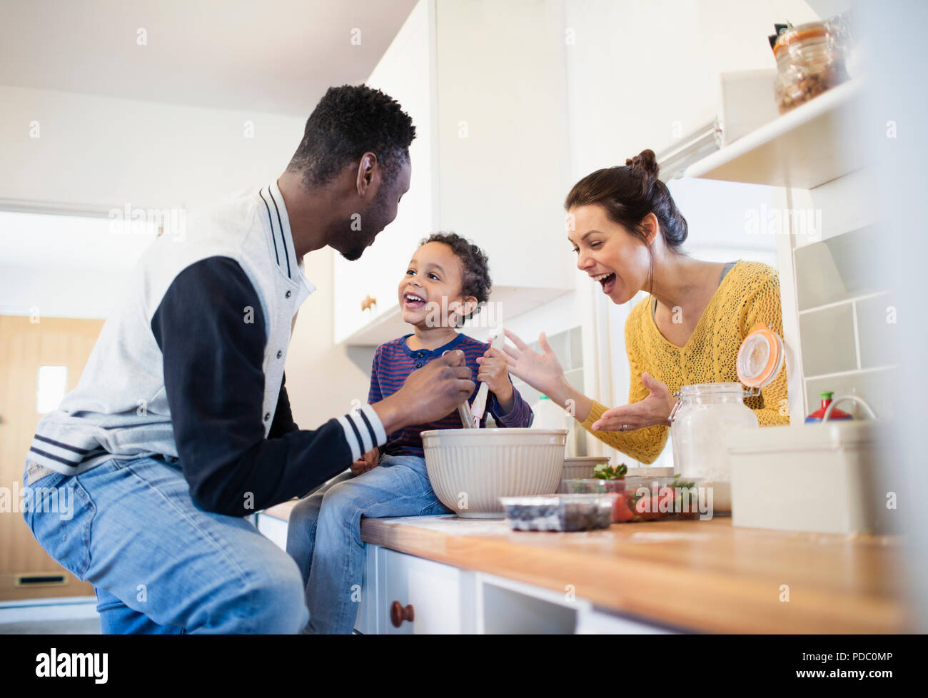 Parents and toddler son baking in kitchen Stock Photo
