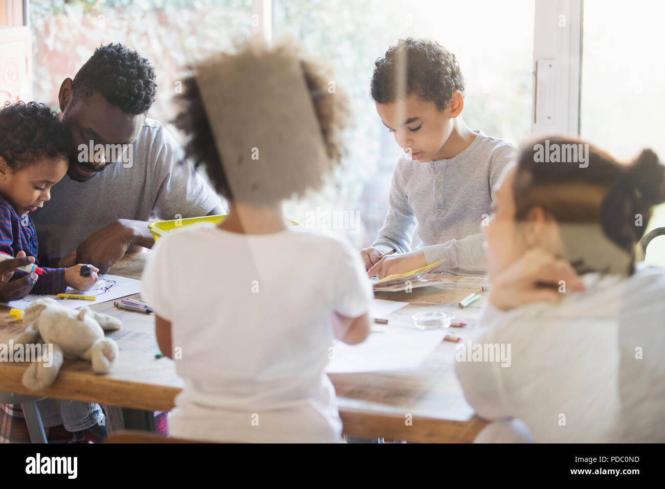 Young family coloring at dining table Stock Photo