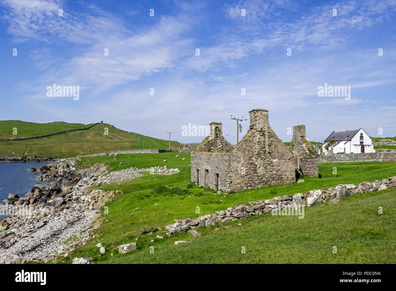 Ruin of old fishing booth and 18th century Lunna Kirk at East Lunna Voe, Lunna Ness, Mainland, Shetland Islands, Scotland, UK Stock Photo