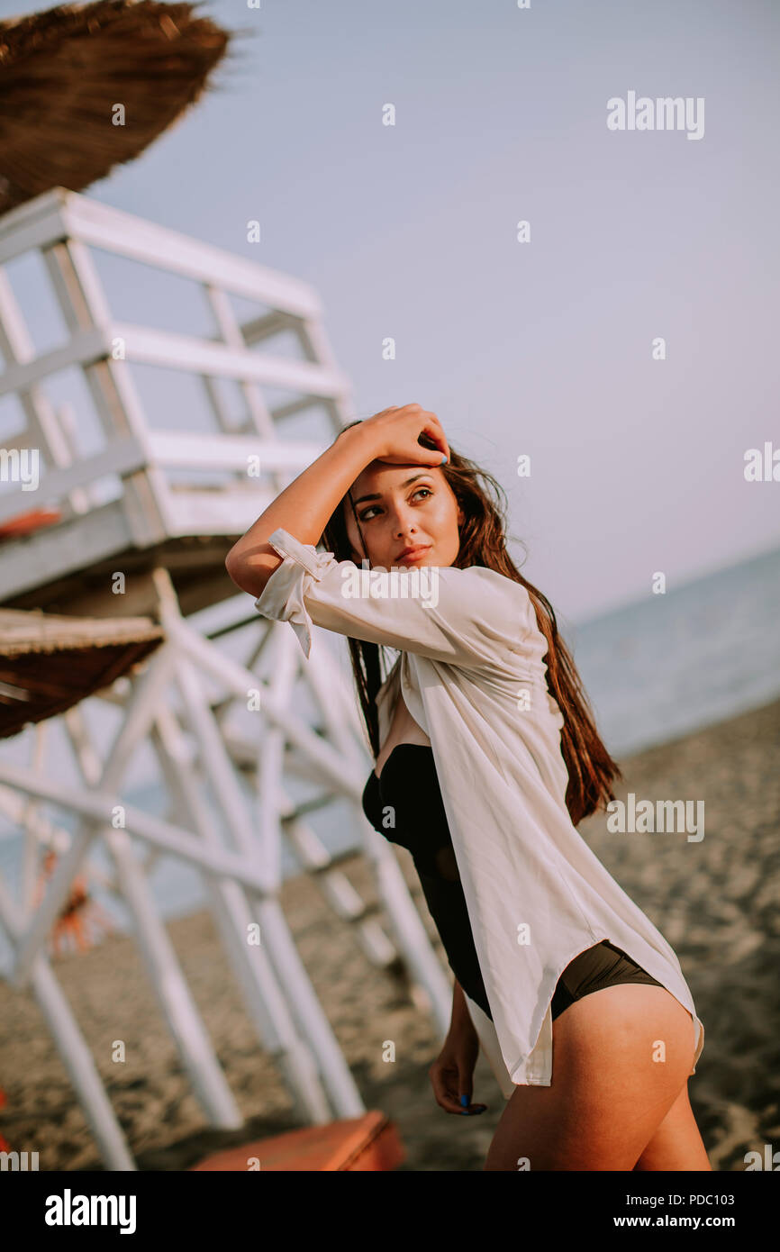 View at young woman posing on the beach by lifeguard observation tower Stock Photo