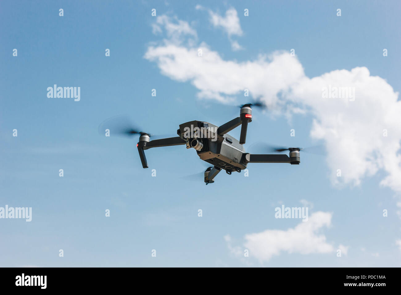 controlled modern drone flying in blue sky Stock Photo - Alamy