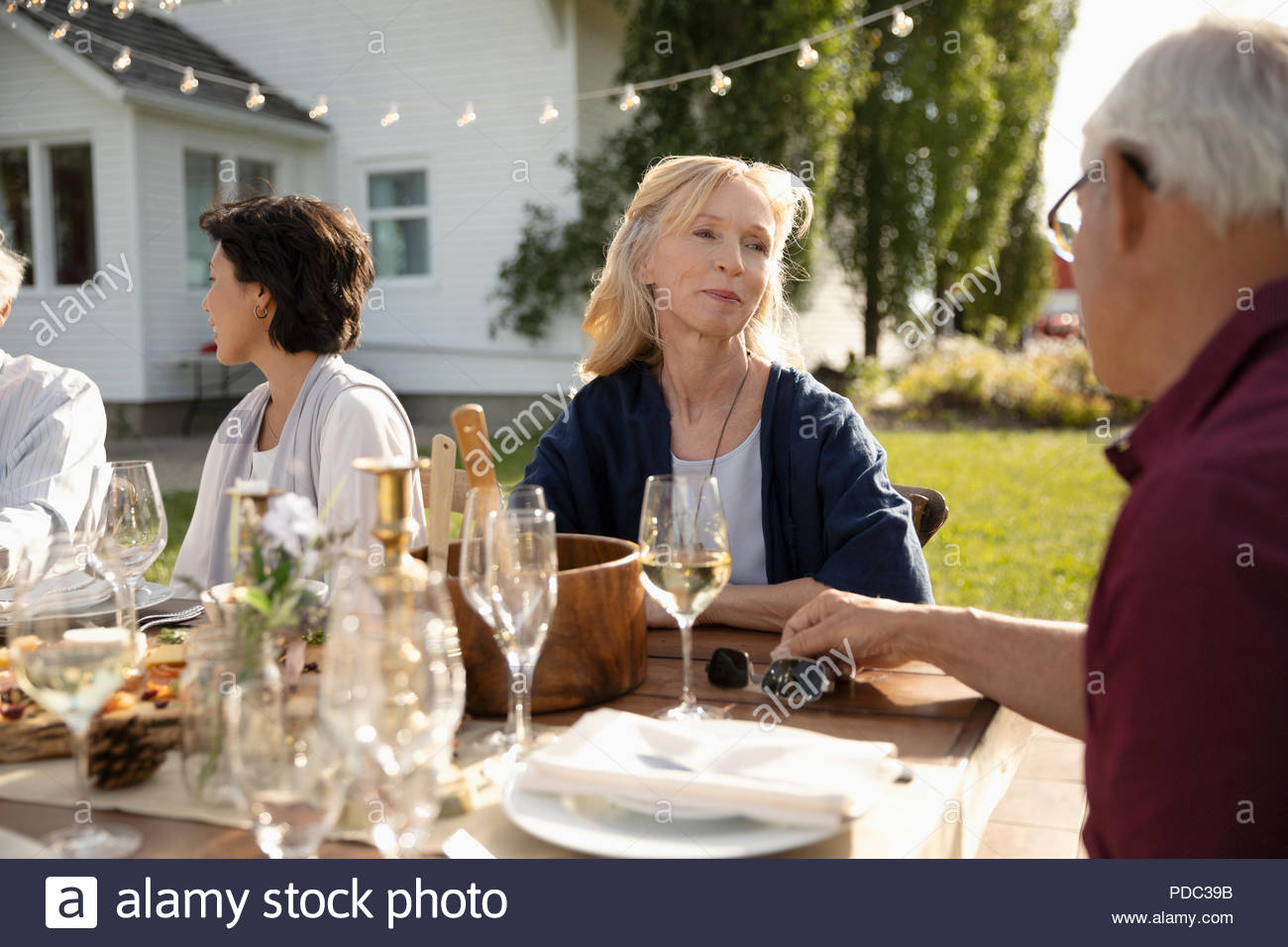 Couple Talking At Wedding Reception Lunch In Sunny Rural Garden