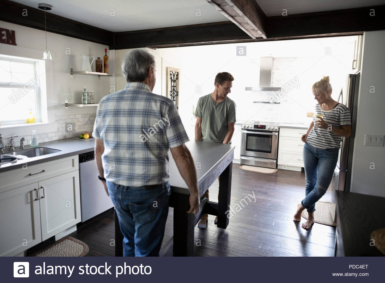 Father and son moving kitchen island Stock Photo Alamy