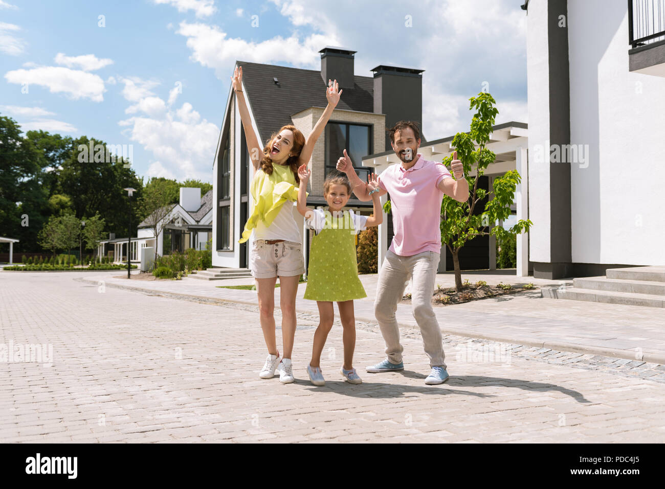 Joyful positive family holding their hands up Stock Photo - Alamy