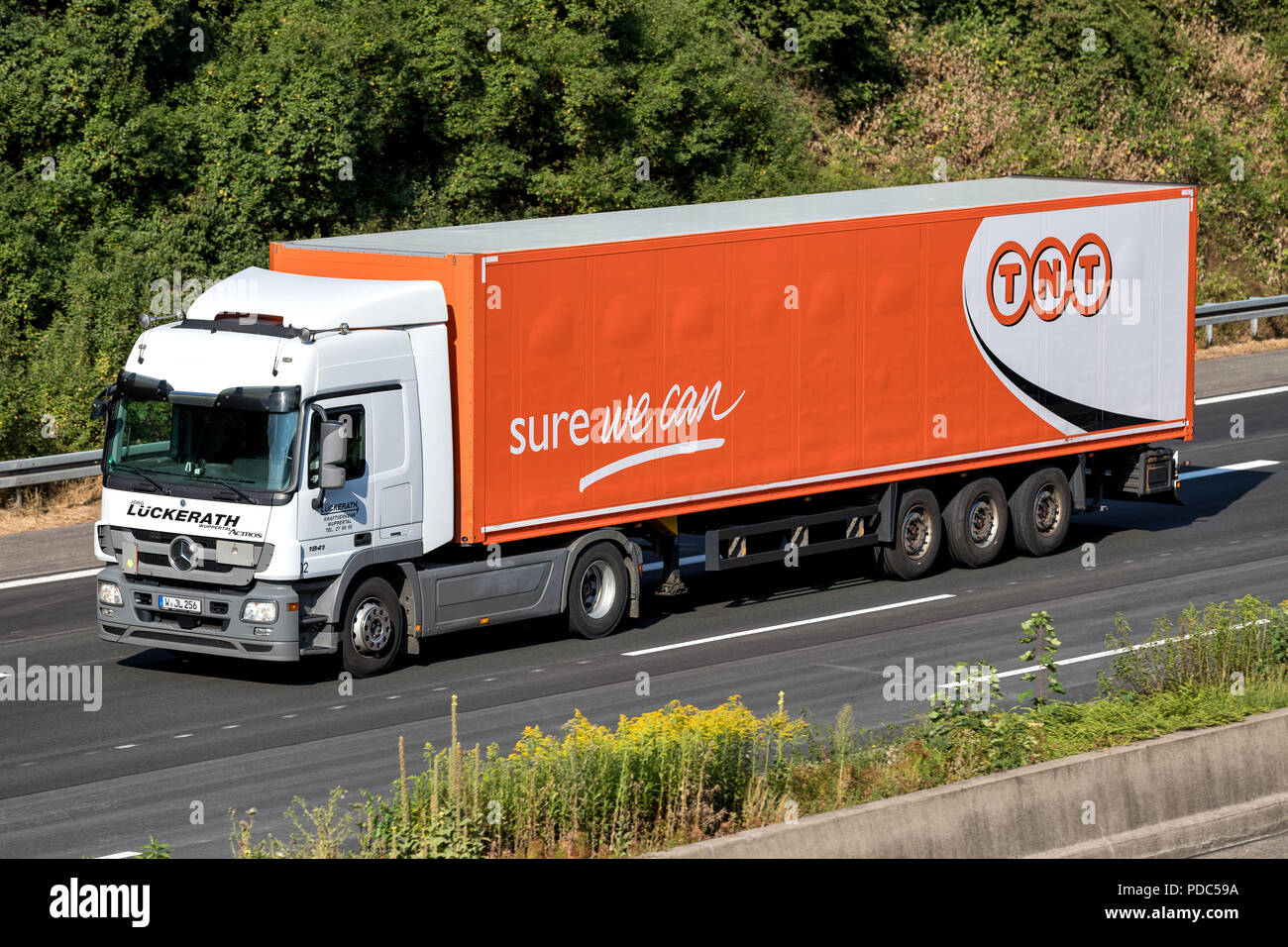 TNT truck on motorway. TNT Express is an international courier delivery services company with headquarters in the Netherlands. Stock Photo