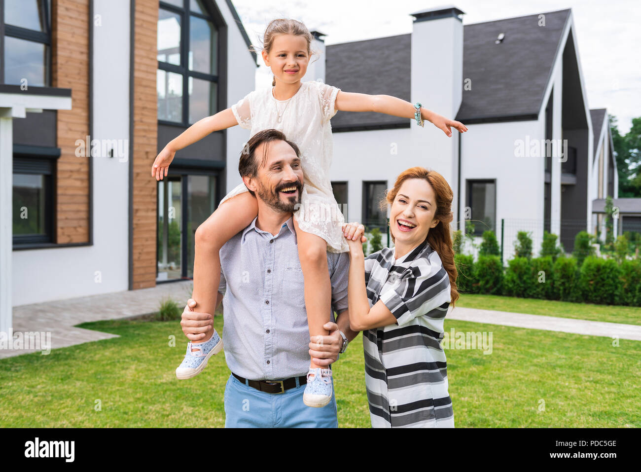Nice cute girl sitting on her fathers shoulders Stock Photo
