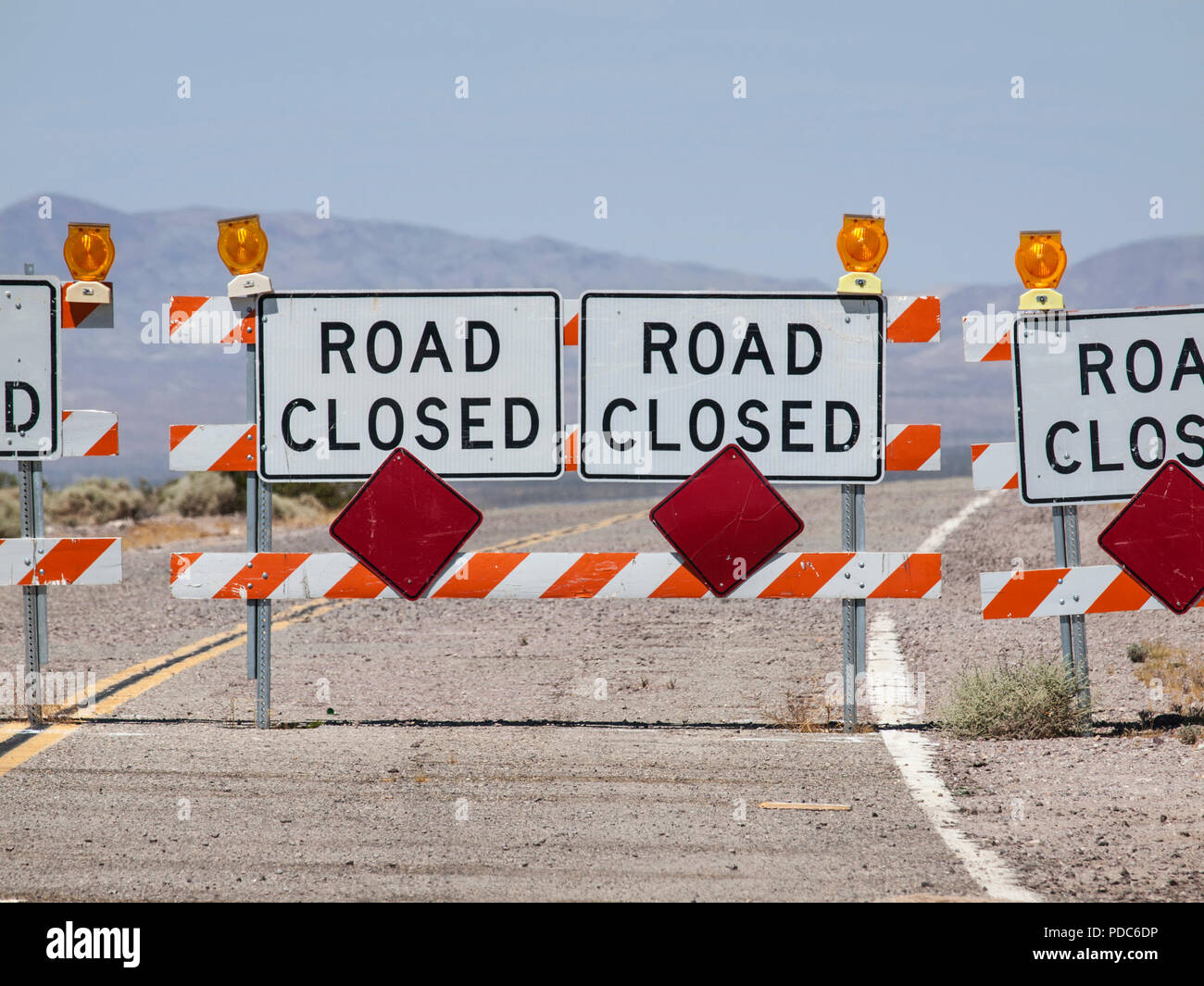 Highway road closure signs and barricades near Route 66 in the California Mojave Desert. Stock Photo