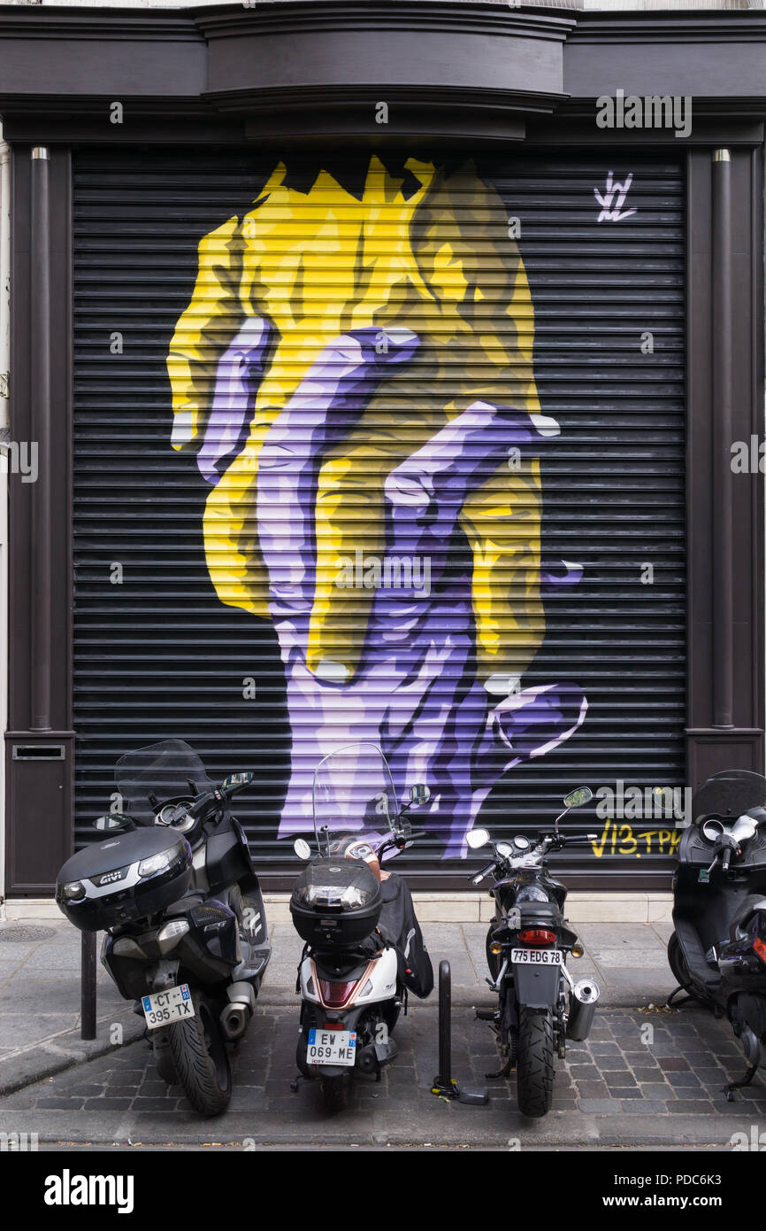 Paris street art - Graffiti of intertwined hands on the closed roller blinds of a clothes store in Paris, France, Europe. Stock Photo