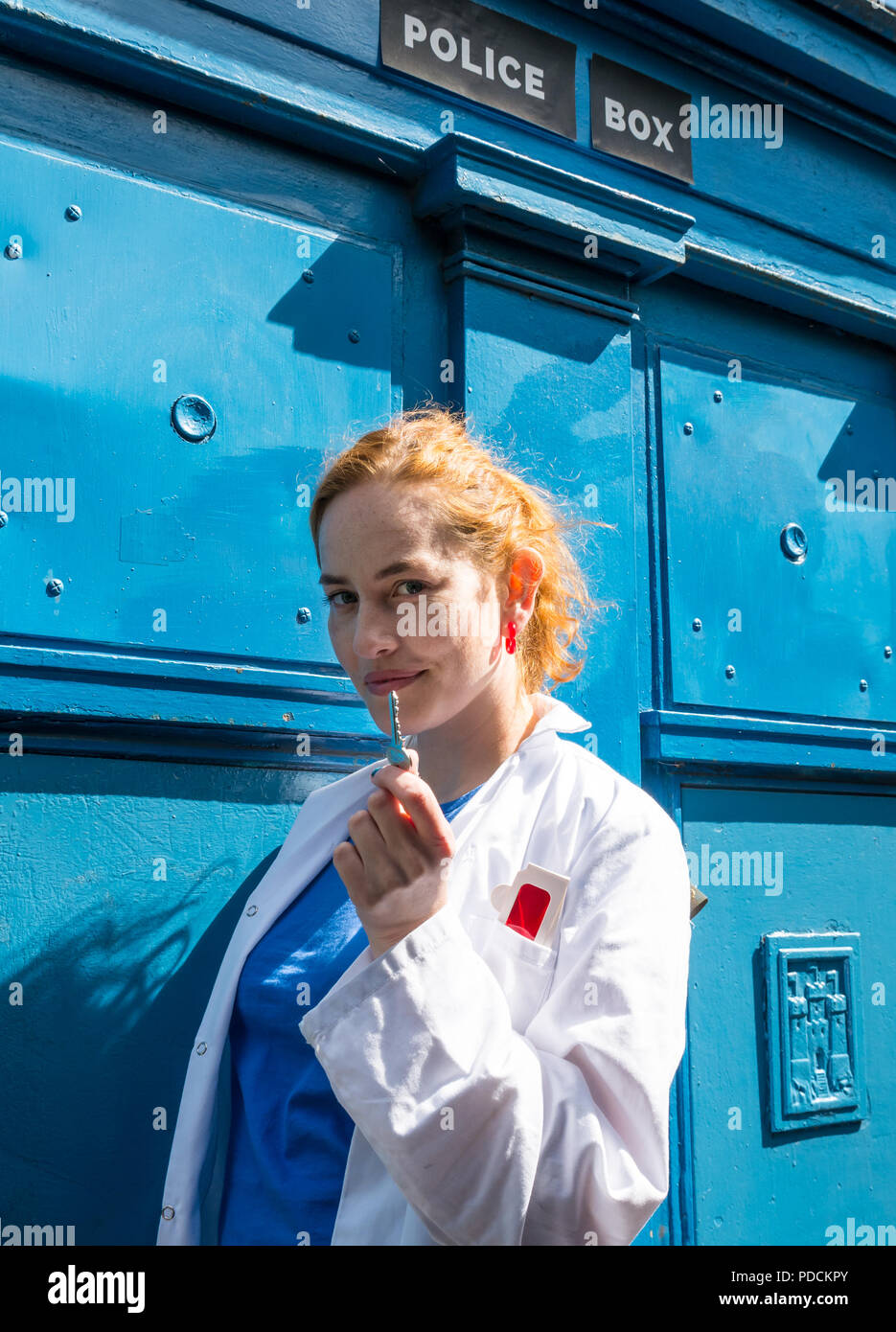 Edinburgh, Scotland, UK. 9th August 2018. Edinburgh Fringe Festival Photocall, Police Call Box, Leamington Terrace, Dr Rosy Carrick is a writer, performer, translator and compere. In her show, Passionate Machine, Rosy builds a time machine to rescue her future self, stuck 100 years in the past. Rosy in her time travelling costume trying to unlock a Tardis Stock Photo