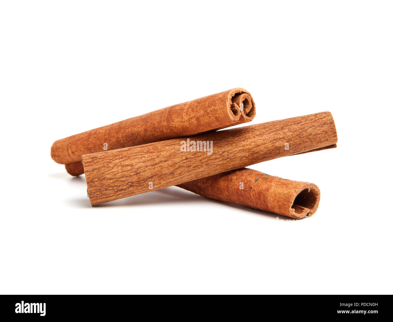 three cinnamon quills stacked on white background Stock Photo Alamy