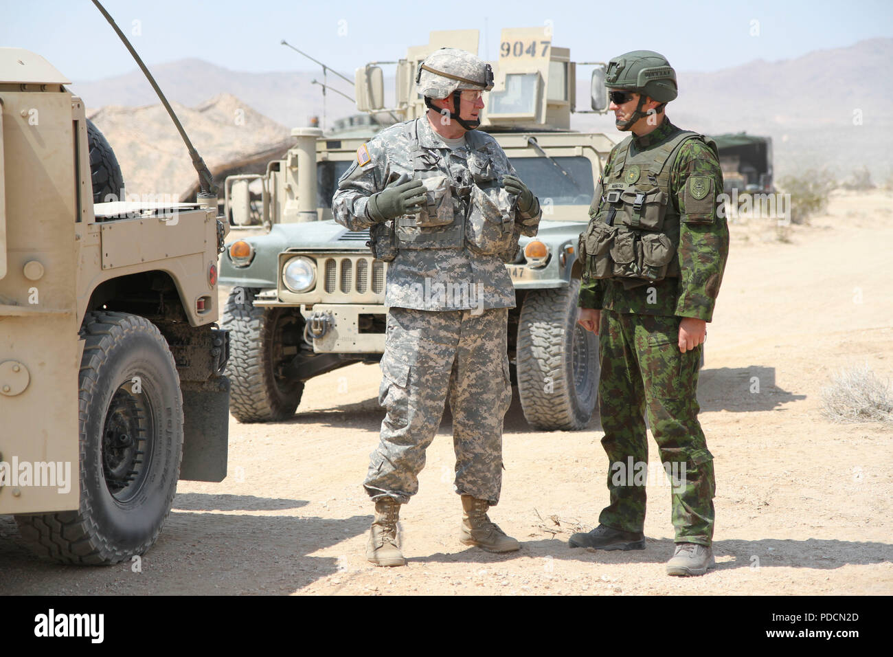 Lt. Col. Louis Gansell, Chief of Information Operations, 28th Infantry Division, Pennsylvania Army National Guard, converses with Maj. Aurelijus Neifaltas, a battalion chief of staff in the Iron Wolf Brigade, Lithuanian Land Forces, Aug. 5 at the National Training Center, Fort Irwin, Ca. The Pennsylvania National Guard and the Lithuanian Armed Forces recently celebrated 25 years of successful partnership. (US Army National Guard photo by Spc. Jake Hoffman) Stock Photo