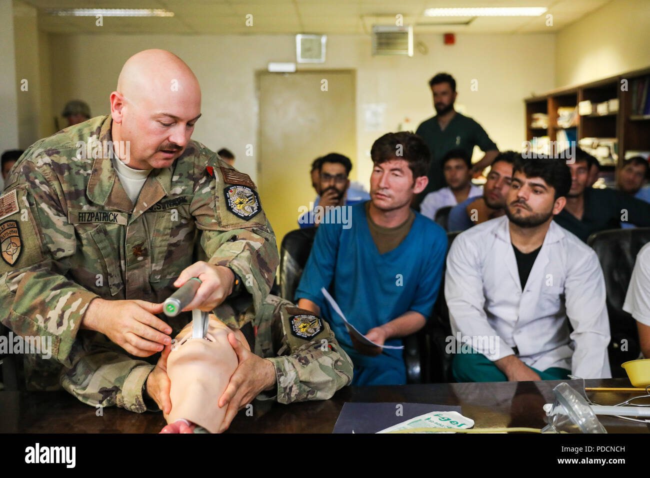 KANDAHAR PROVINCE, Afghanistan (August 5, 2018) --  U.S. Navy Lt. Cdr. Travis J. Fitzpatrick, senior nurse for Kandahar Airfield NATO Role III Multinational Medical Unit, demonstrates a technique on how to clear the airway of a patient, August 5, 2018, to Afghan medical staff members during a medical advisory visit at Kandahar Regional Military Hospital, Camp Hero in Kandahar, Afghanistan. Staff members from the Role III conduct routine visits to KRMH to train and advise Afghan medical staff. (U.S. Army photo by Staff Sgt. Neysa Canfield/TAAC-South Public Affairs) Stock Photo