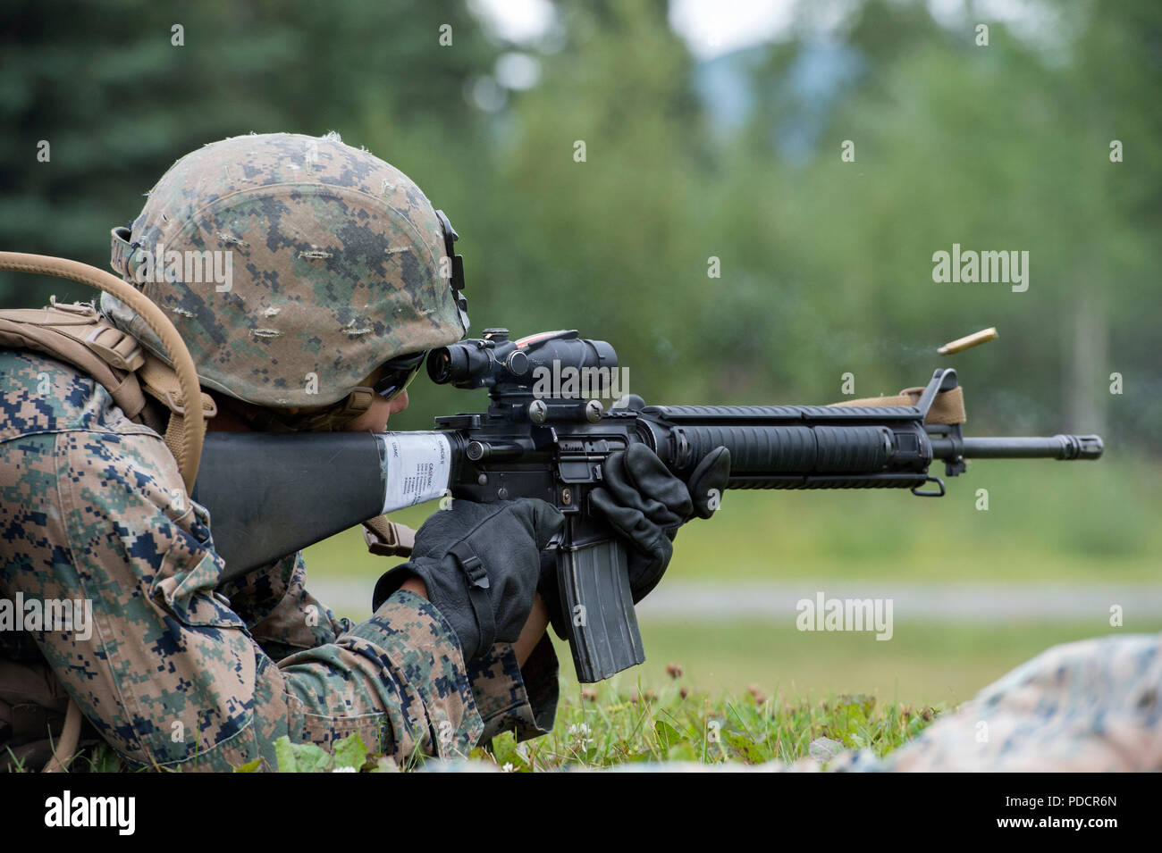 U.S. Marine Corps Lance Cpl. Ismael Garcia II, assigned to Charlie Company, 1st Battalion, 23rd Marine Regiment, fires his M16A4 rifle from the 600 yard line during the 4th Marine Division Super Squad Competition live-fire marksmanship event held at Joint Base Elmendorf-Richardson, Alaska, Aug. 6, 2018. During the multi-day competition, squads from 1st and 3rd Battalions, 23rd Marine Regiment and 1st Battalion, 24th Marine Regiment, exercised their technical and tactical proficiencies by competing in events that highlighted offensive/defensive operations, patrolling techniques, combat marksman Stock Photo