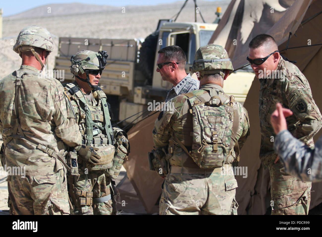 Gen. Joseph Lengyel, chief, National Guard Bureau, converses with Command Sgt. Maj. Randall Pritts of the 56th Stryker Brigade Combat Team Aug.6 at the National Training Center, Fort Irwin, Ca. Command Sgt. Maj. Christopher Kepner, Senior Enlisted Advisor to the Chief of the National Guard Bureau, talks with Col. Marc. Ferraro, 28th Infantry Division Rear Detachment Commander, in the foreground. (US Army National Guard Photo by Spc. Jake Hoffman) Stock Photo