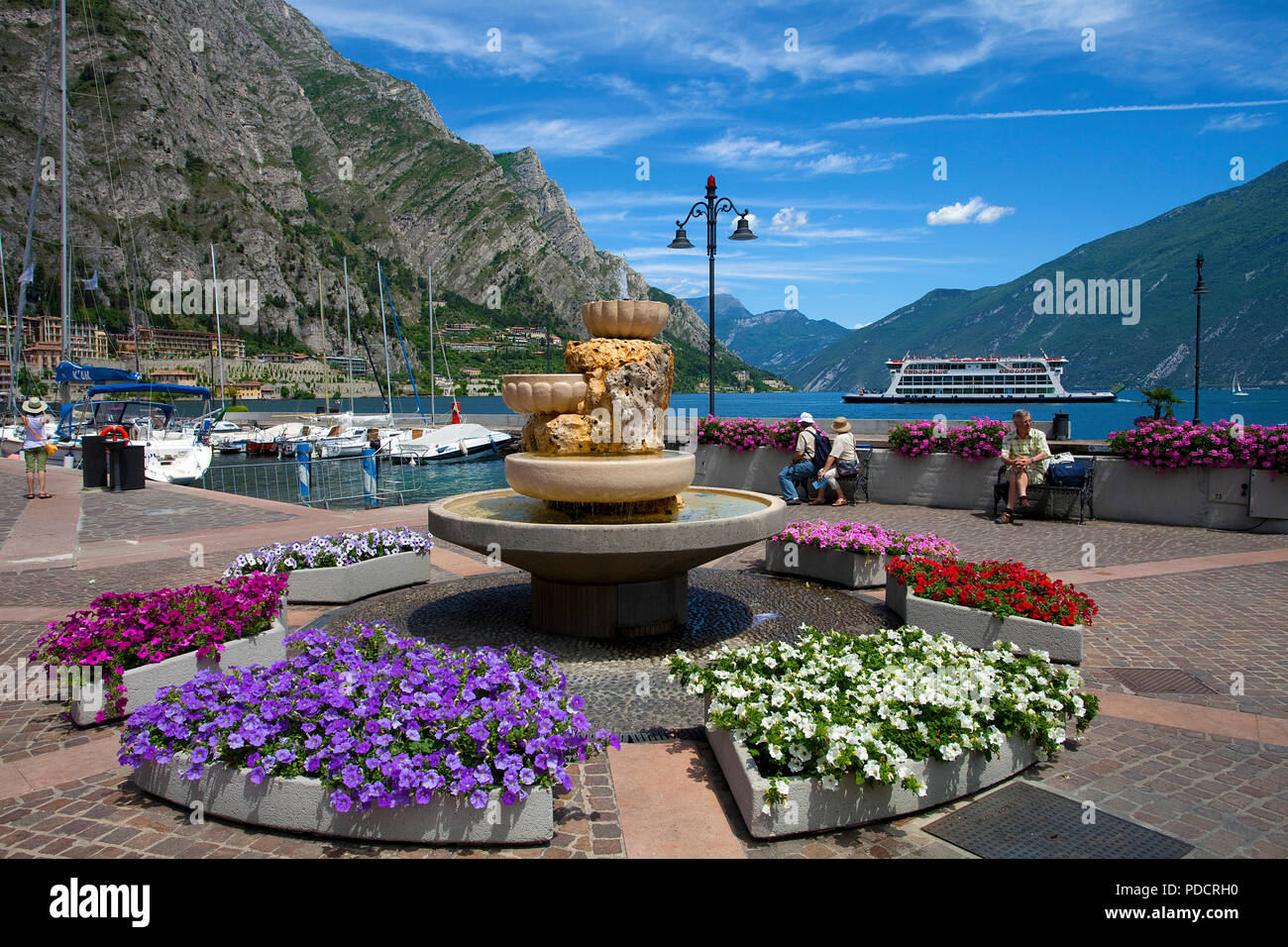 Flower decoration at lake promenade, fountain, Limone, Limone sul Garda, Lake Garda, Lombardy, Italy Stock Photo