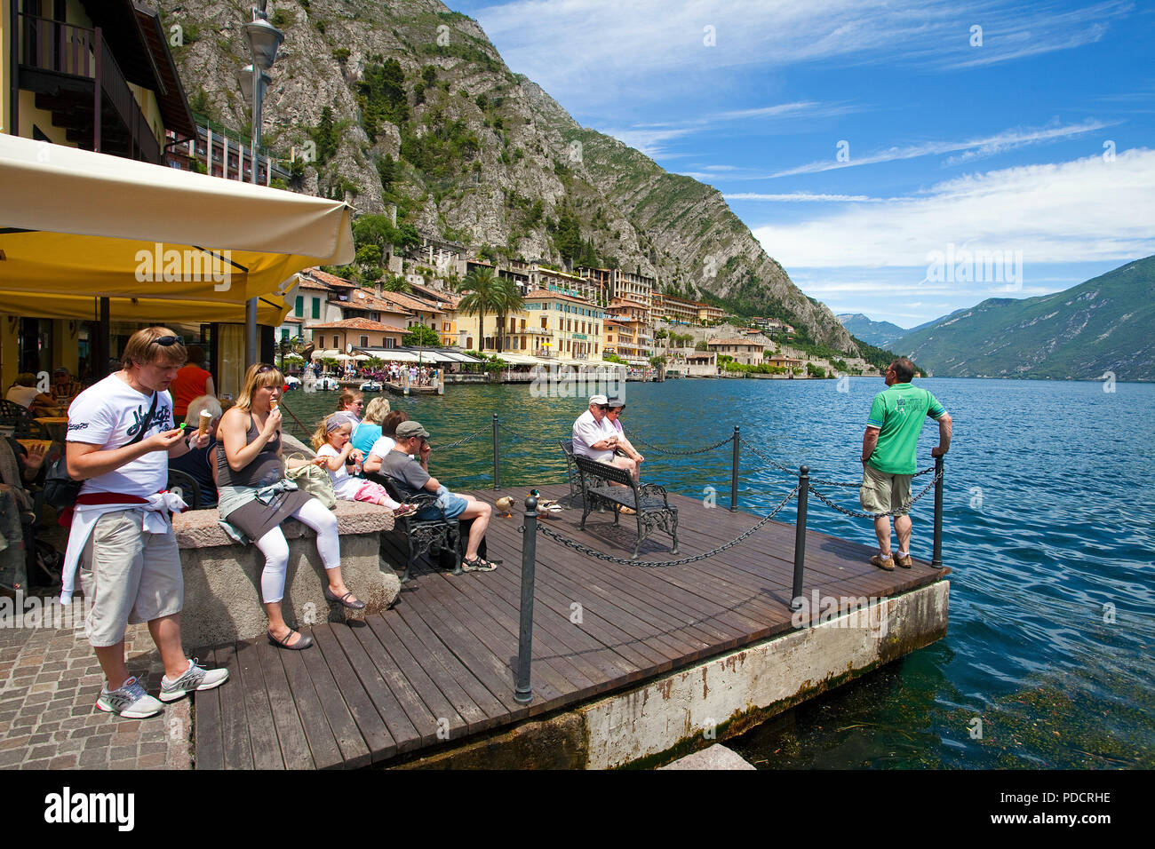 Tourist on a dock at lakeside of Limone, Limone sul Garda, Lake Garda, Lombardy, Italy Stock Photo