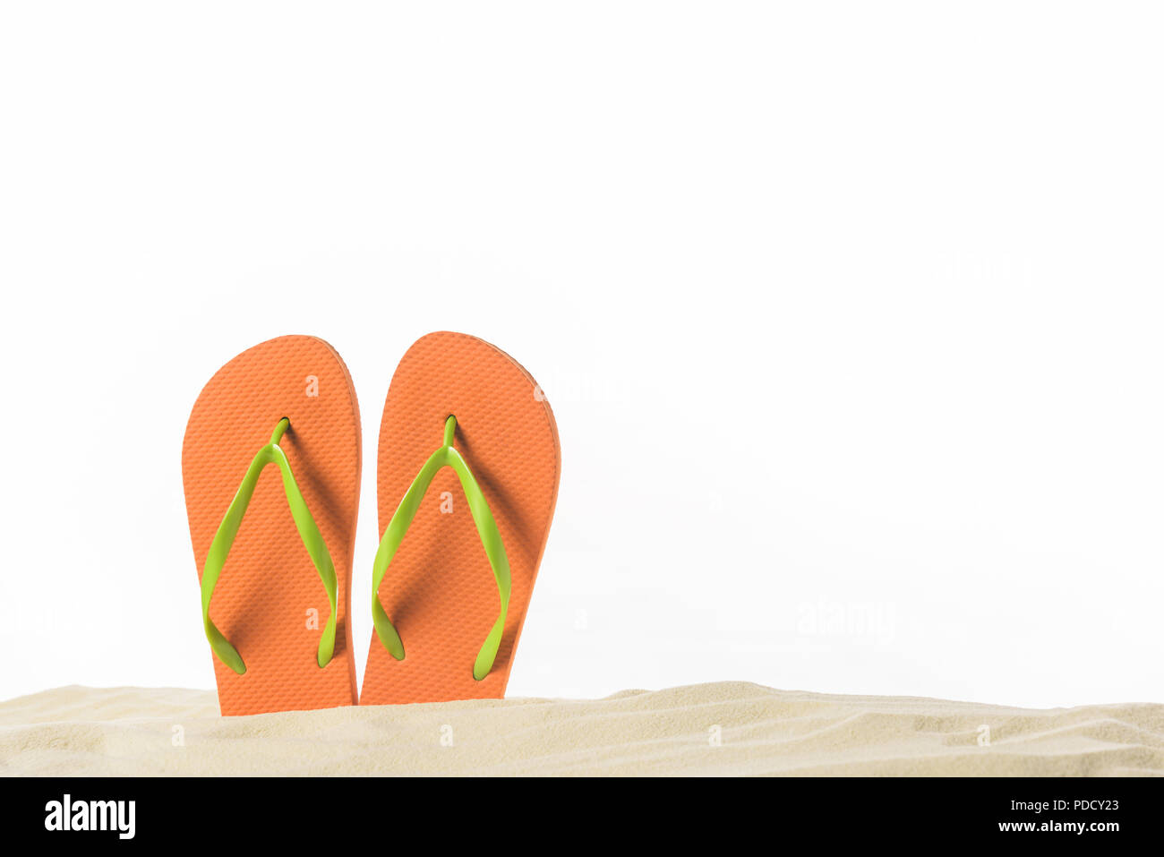 Pair of flip flops in sand isolated on white Stock Photo - Alamy