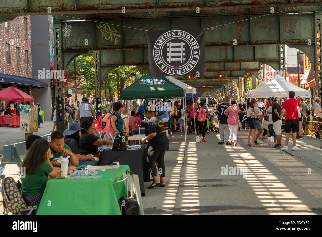 Tabling under the elevated train on Broadway in the Bushwick neighborhood of New York during the 'Block Party on Broadway' street fair on Sunday, August 5, 2018. The fair, sponsored by the Broadway Merchants Association, is in response to the K2 epidemic which has effected the Broadway corridor and is endeavoring to bring people back.  (© Richard B. Levine) Stock Photo