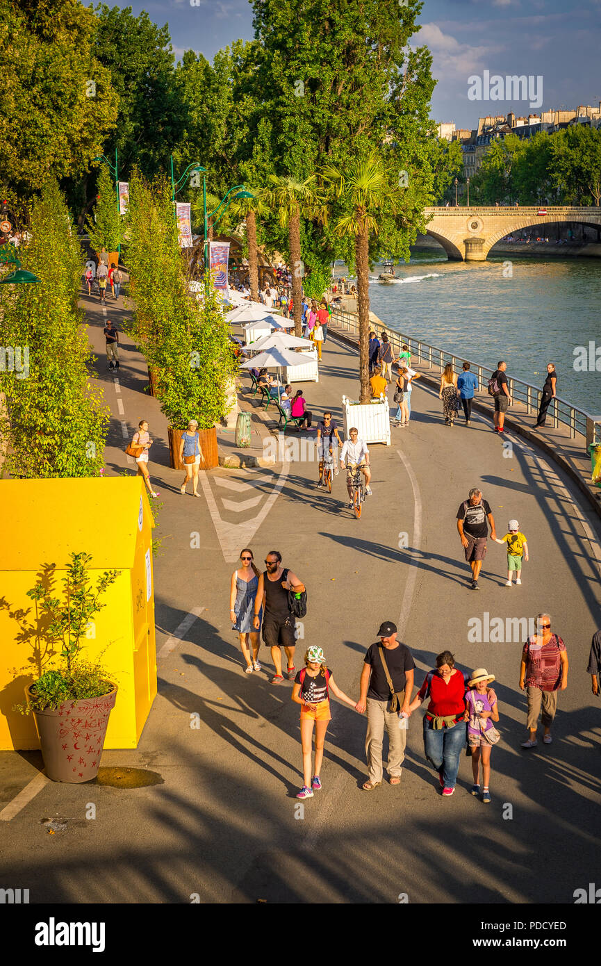 Parc Rives de Seine is a favourite place for tourists and locals to walk by the Seine River late in the afternoon in summer during the Paris plages. Stock Photo