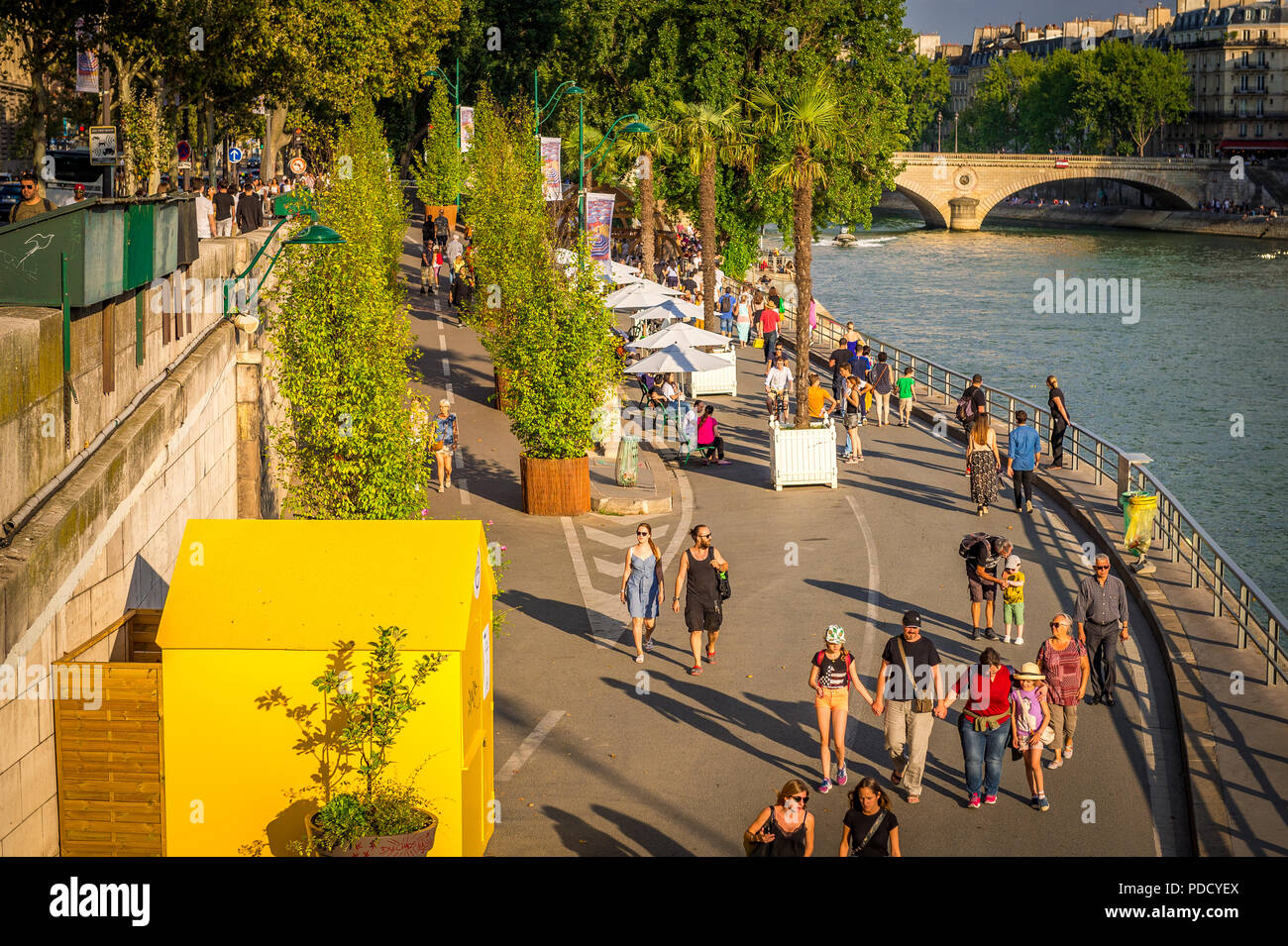 Parc Rives de Seine is a favourite place for tourists and locals to walk by the Seine River late in the afternoon in summer during the Paris plages. Stock Photo