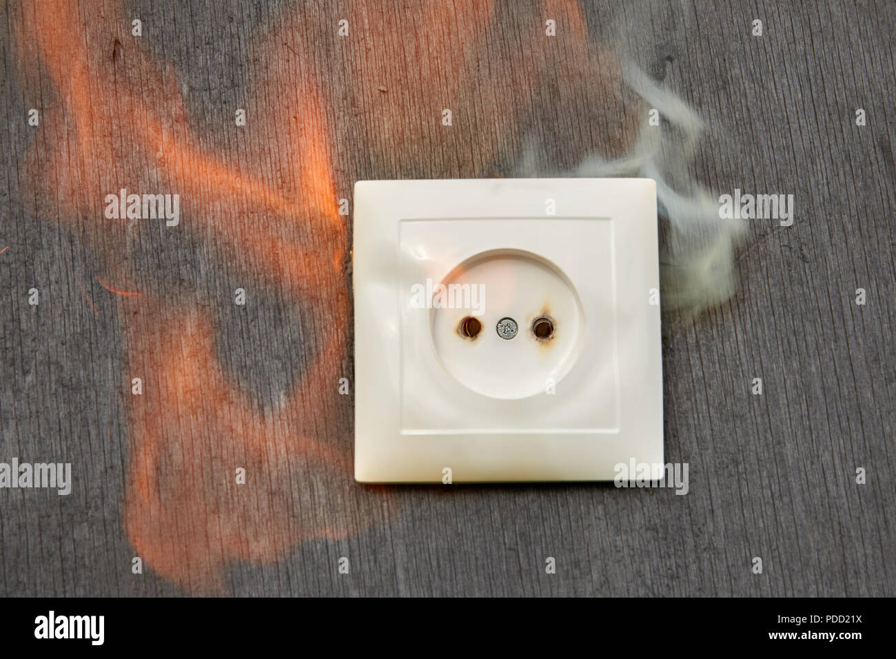 Household fire, Ignition of the plastic wall socket. Stock Photo