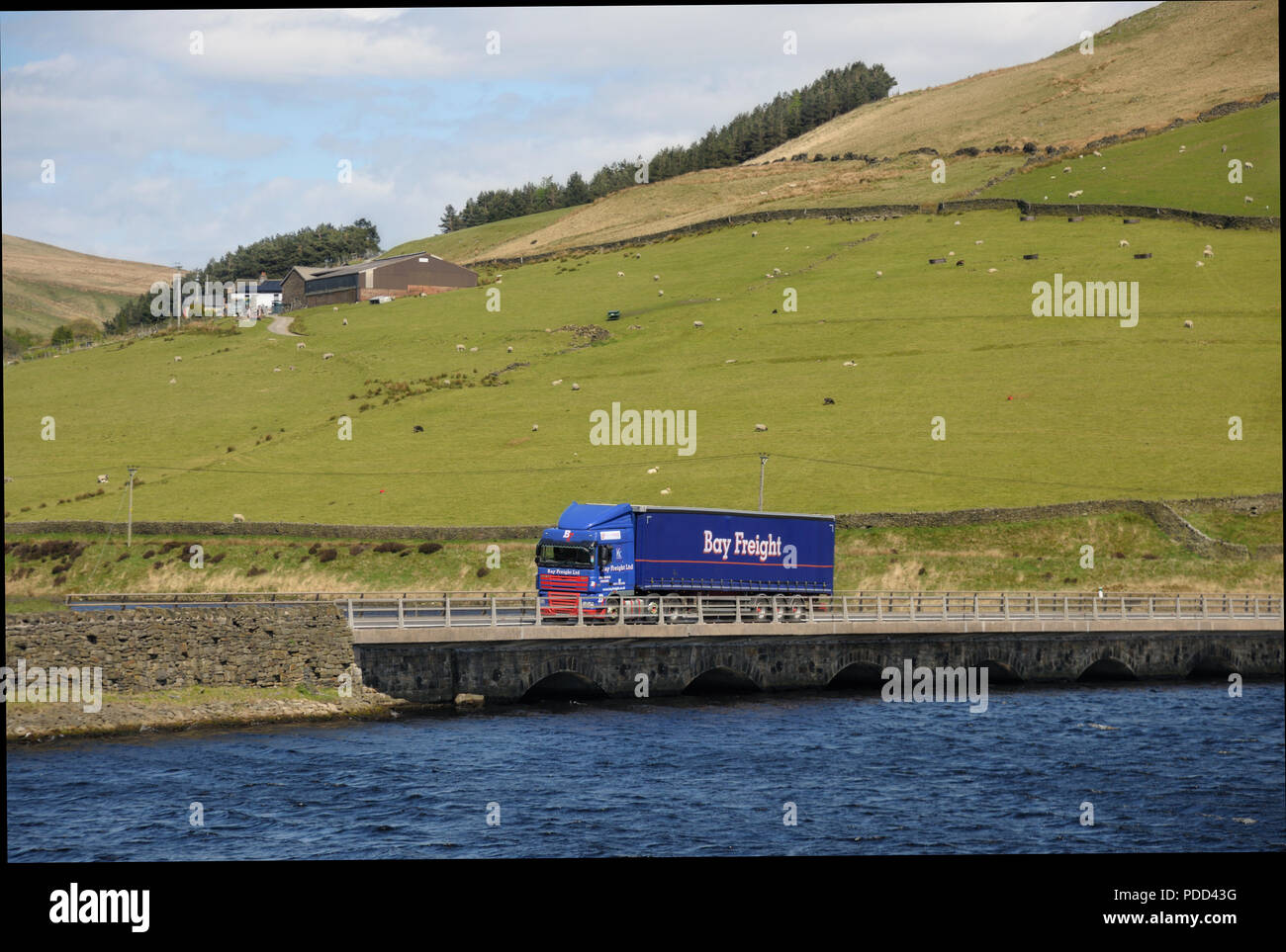 A Bay Freight DAF Truck with curtainsider trailer crossing the bridge over Woodhead Reservoir on the Woodhead PAss, Yorkshire Stock Photo