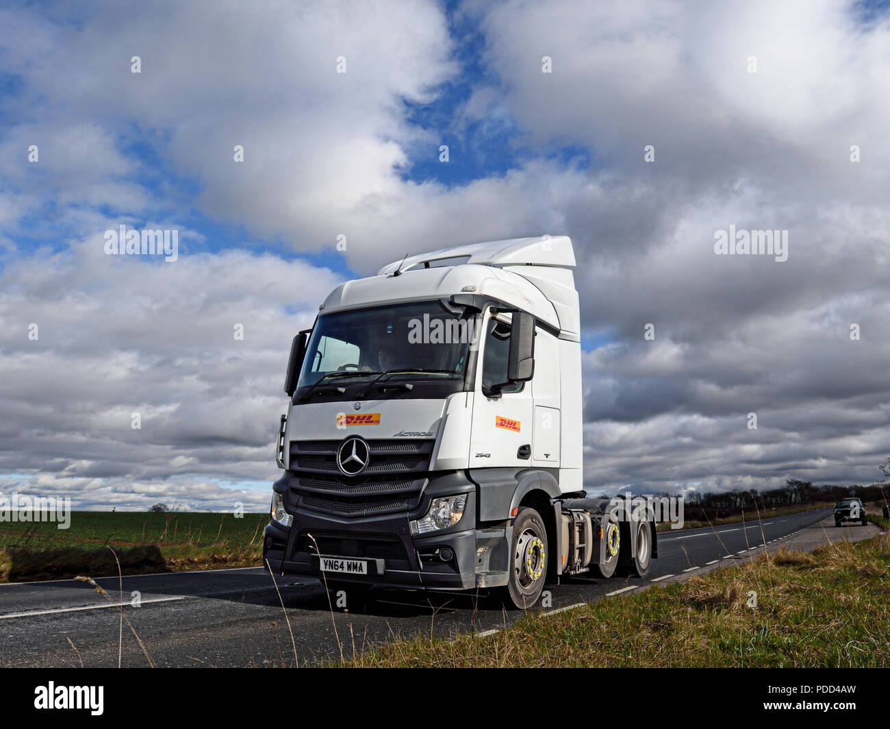 DHL Mercedes-Benz Actros truck driving without trailer along a rural A road Stock Photo