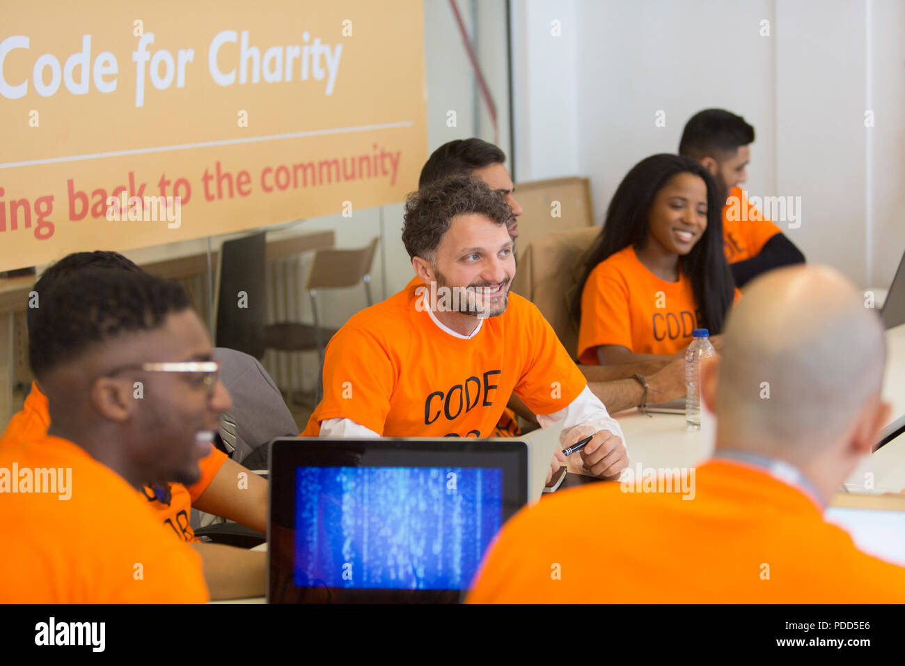 Hackers coding for charity at hackathon Stock Photo