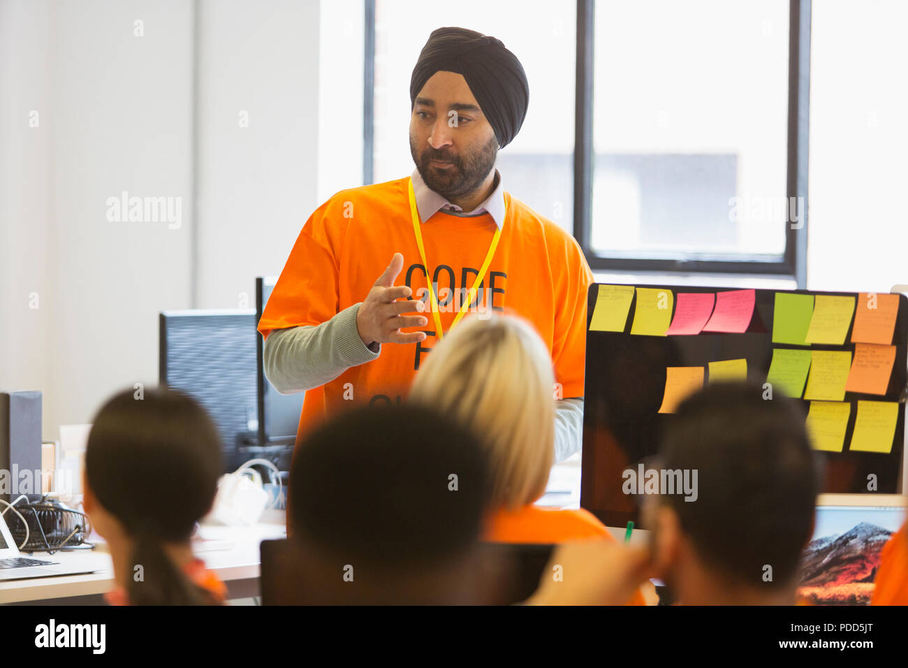 Hacker in turban leading meeting, coding for charity at hackathon Stock Photo