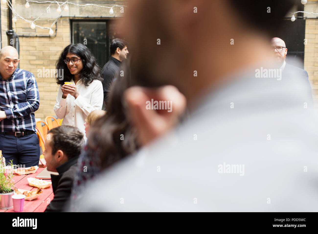 Friends socializing at party on patio Stock Photo