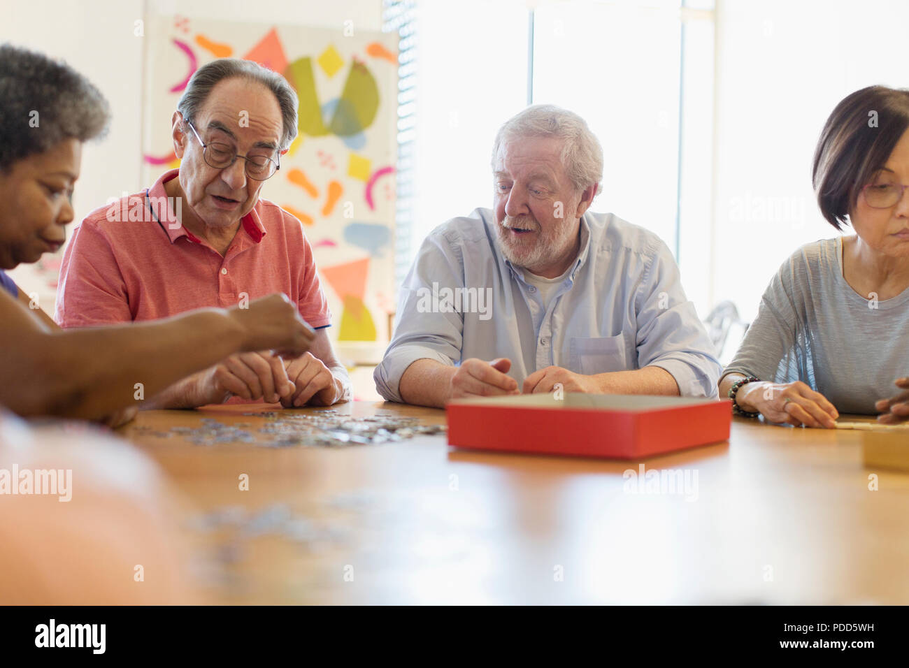 Senior friends playing games at table in community center Stock Photo