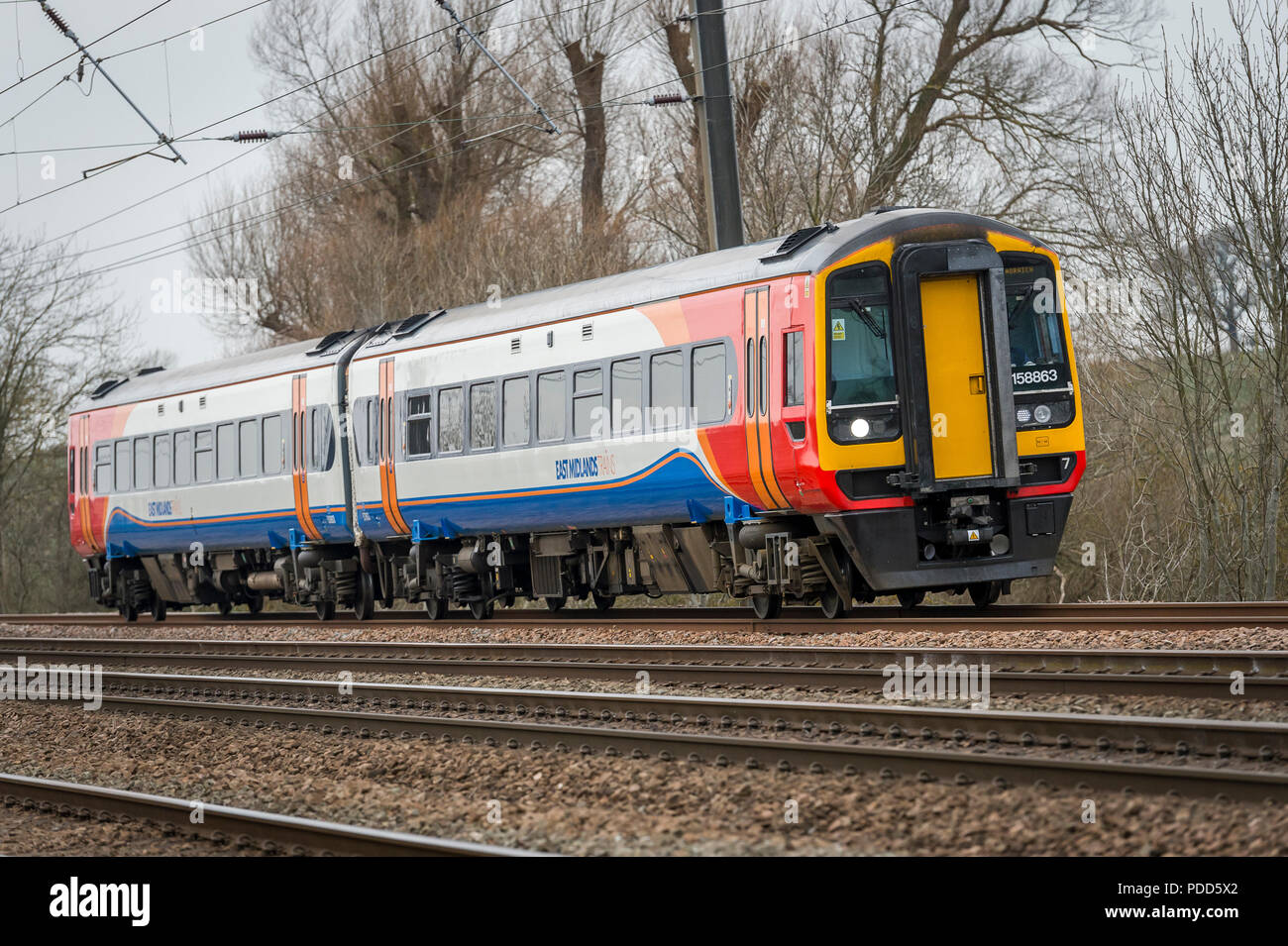 Class 158 train in East Midlands Trains livery travelling through the English countryside. Stock Photo