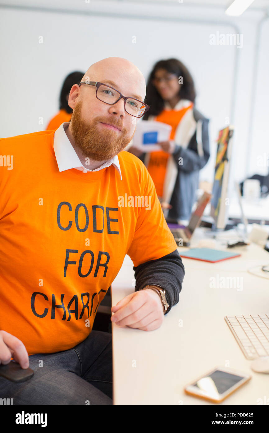 Portrait confident hacker coding for charity at hackathon Stock Photo