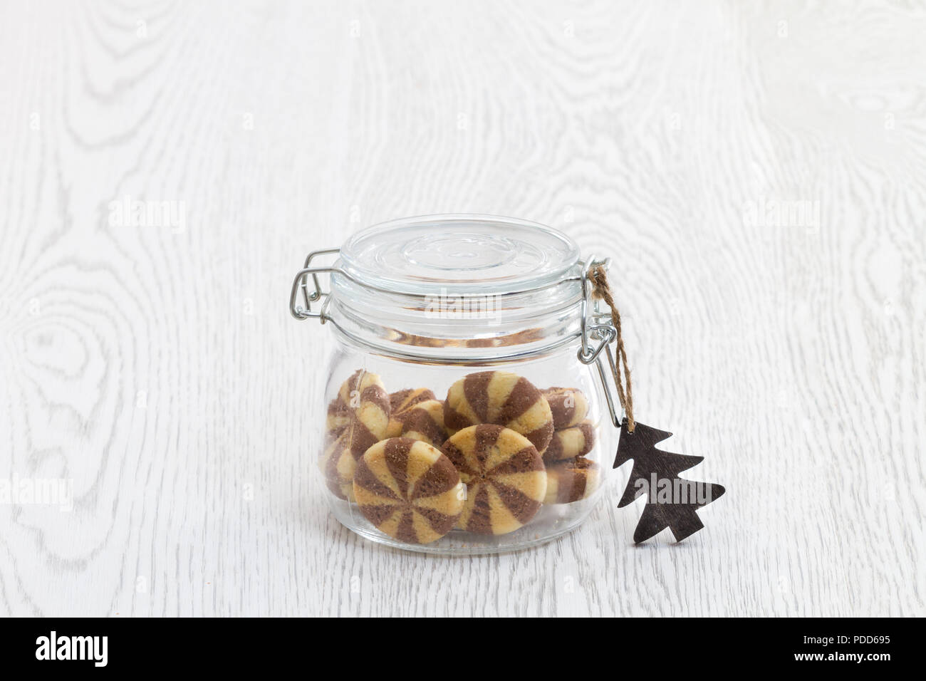 https://c8.alamy.com/comp/PDD695/transparent-retro-cookie-jar-on-white-kitchen-table-with-black-and-white-cookies-and-sezonda-feeling-PDD695.jpg