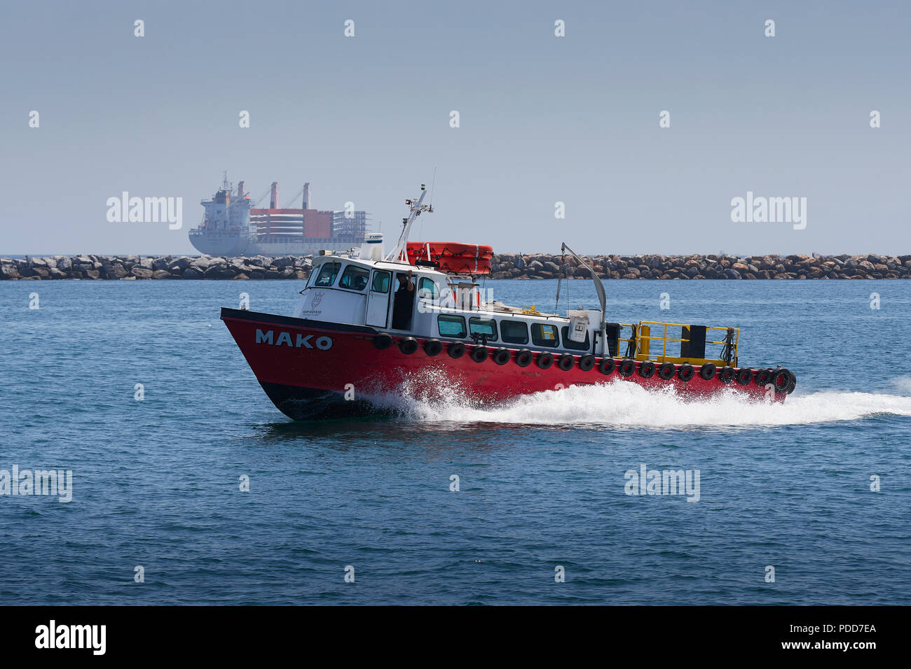 So Cal Ship Services Launch, MAKO, Under Way In The Port Of Long Beach, The Federal Breakwater And An Anchored Cargo Ship Behind. Stock Photo