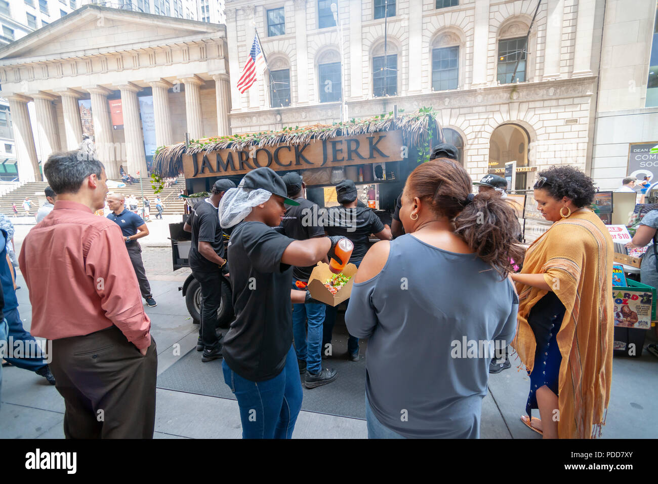 Wall Street workers and tourists line up at the popular Jamrock Jerk food cart on Wall Street in Lower Manhattan in New York on Friday, July 27, 2018. The family-owned and operated cart serves authentic Jamaican dishes to the hungry hordes who line up for a taste of the island. (Â© Richard B. Levine) Stock Photo