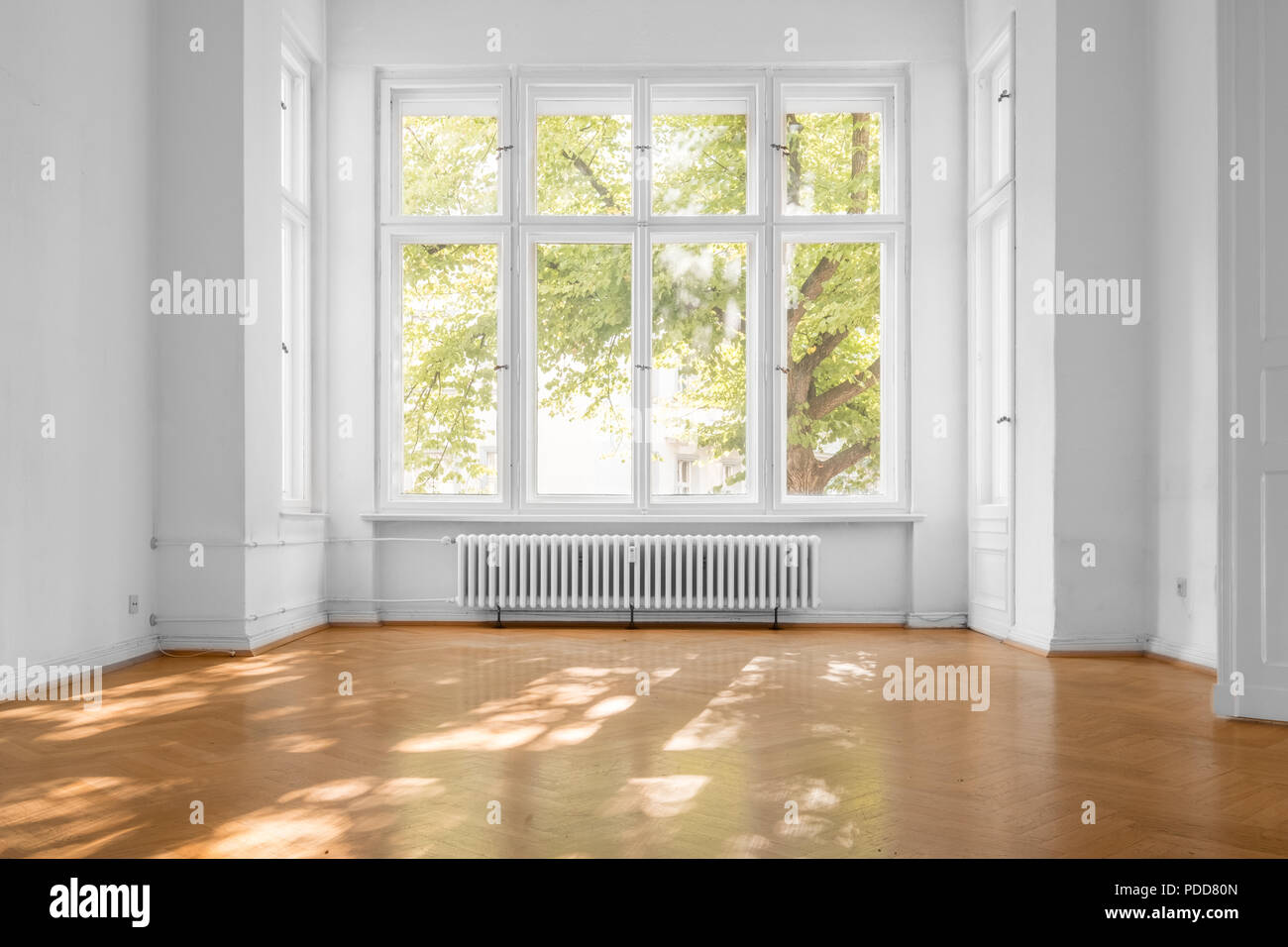 empty room in old apartment building with  parquet floor and big wooden windows - Stock Photo
