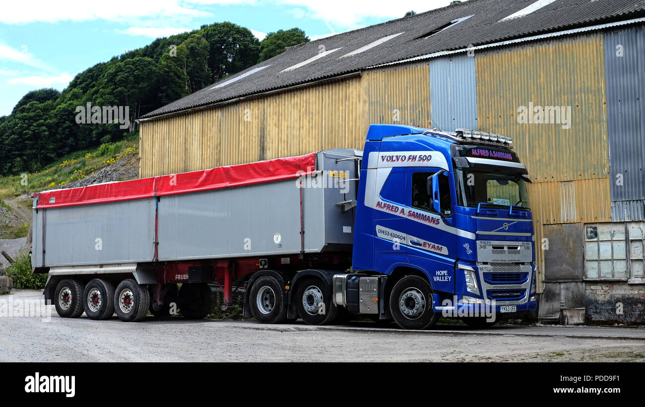 Volvo pulling bulk tipper trailer parked by  quarry buildings Stock Photo