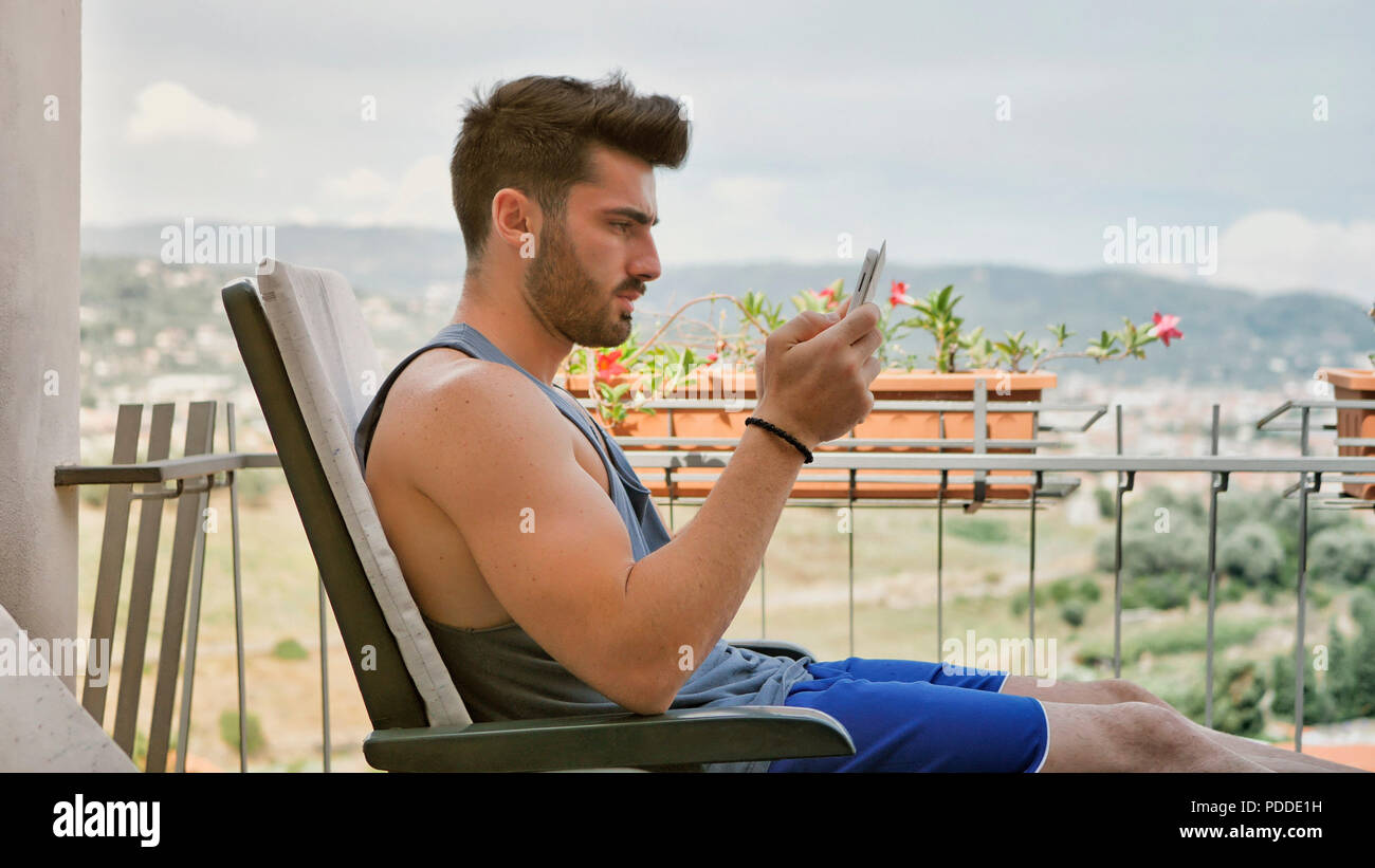 Waist Up Profile Of Attractive Man With Dark Hair Sitting With