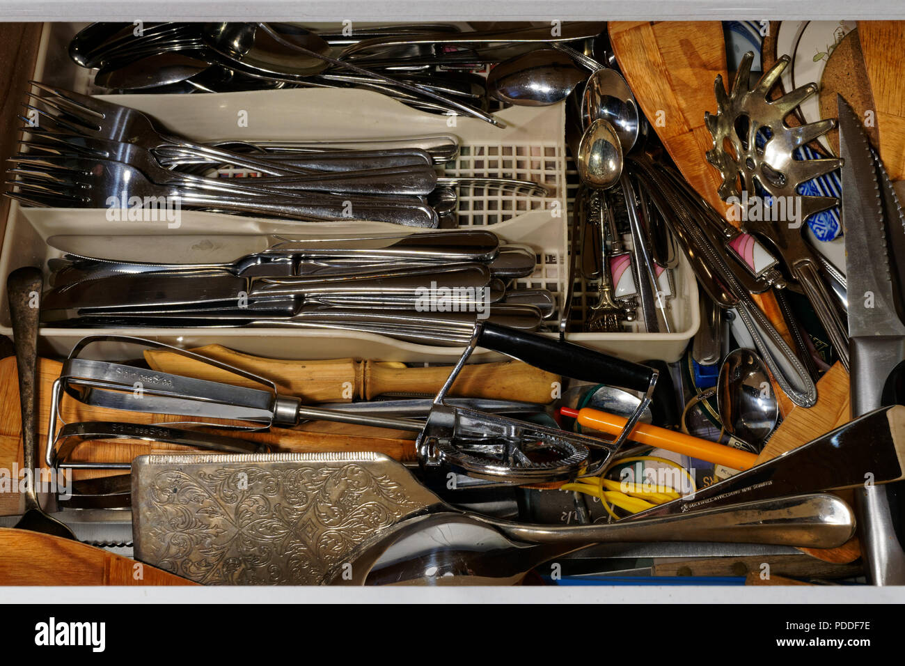 Cluttered cutlery drawer, a lifetime of useful stuff but none of it can be found when it's needed Stock Photo