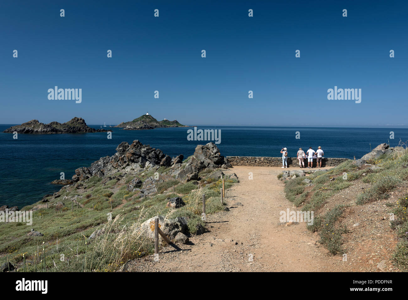 Visitors at the end of the paved path on Pointe de la Parata, ( Point of Parata ) on Corsica towards a chain of small islands, Les Archipel des Sangui Stock Photo