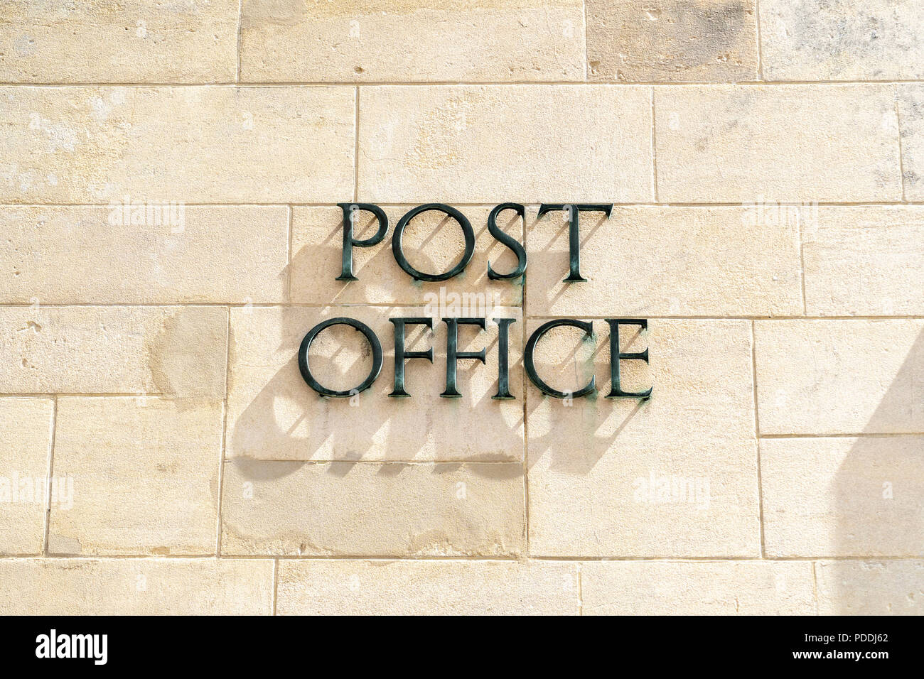 Post Office sign on stone wall Stock Photo