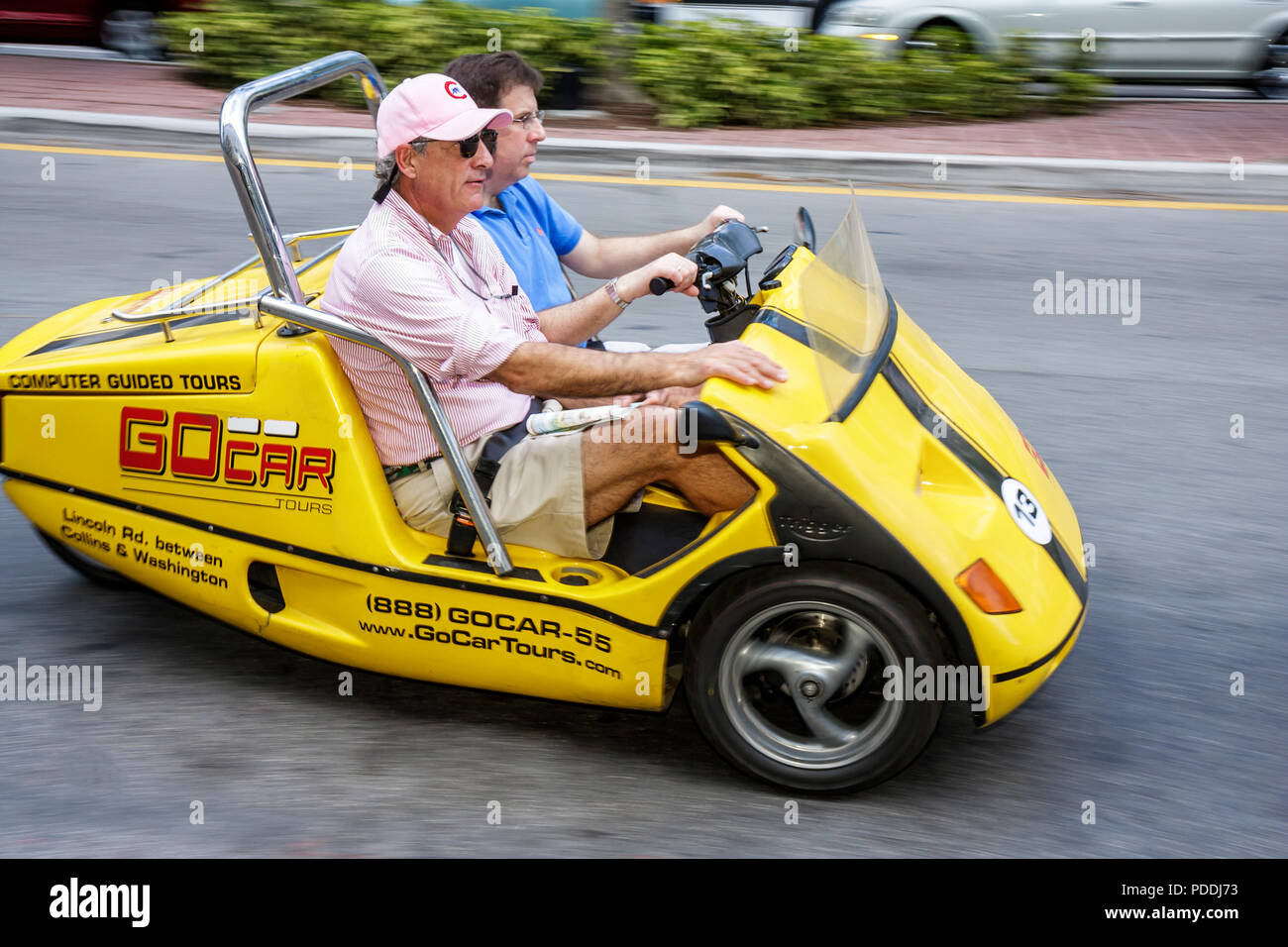 Miami Beach Florida,Washington Avenue,man men male,red,go car,GPS guided tour car,tourists,two seater,entertainment,Trigger Technics BV,Dutch,three 3 Stock Photo