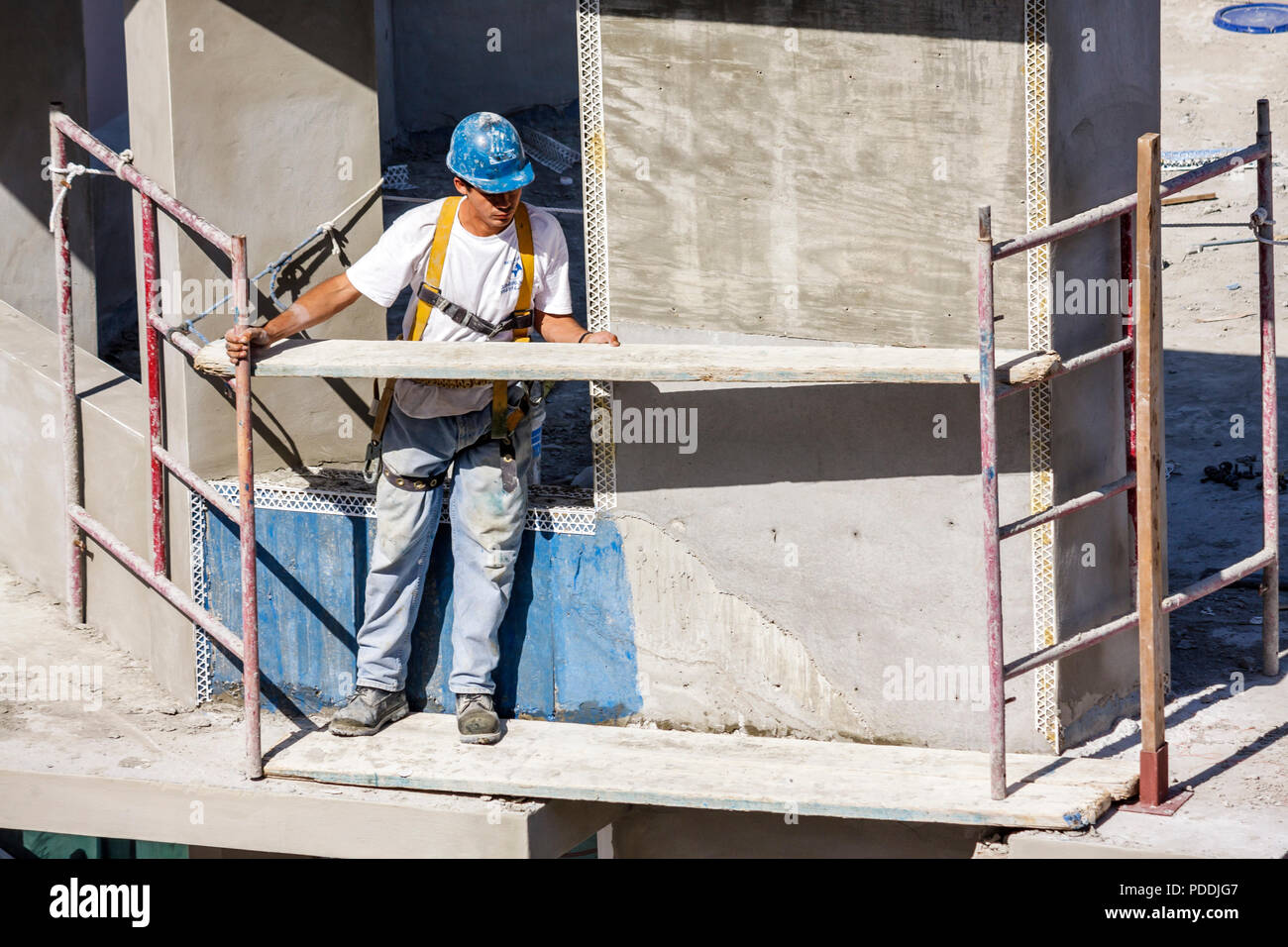 Miami Beach Florida,Ocean Drive,Hispanic man men male,laborer,under new construction site building builder,worker,workers,builder,helmet,scaffold,work Stock Photo