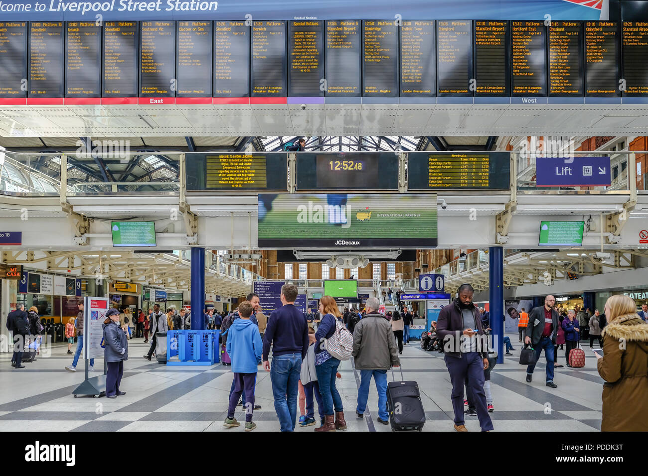 Liverpool Street, London, UK - April 6, 2018: Busy scene inside the station with passengers standing near the destination board. Stock Photo