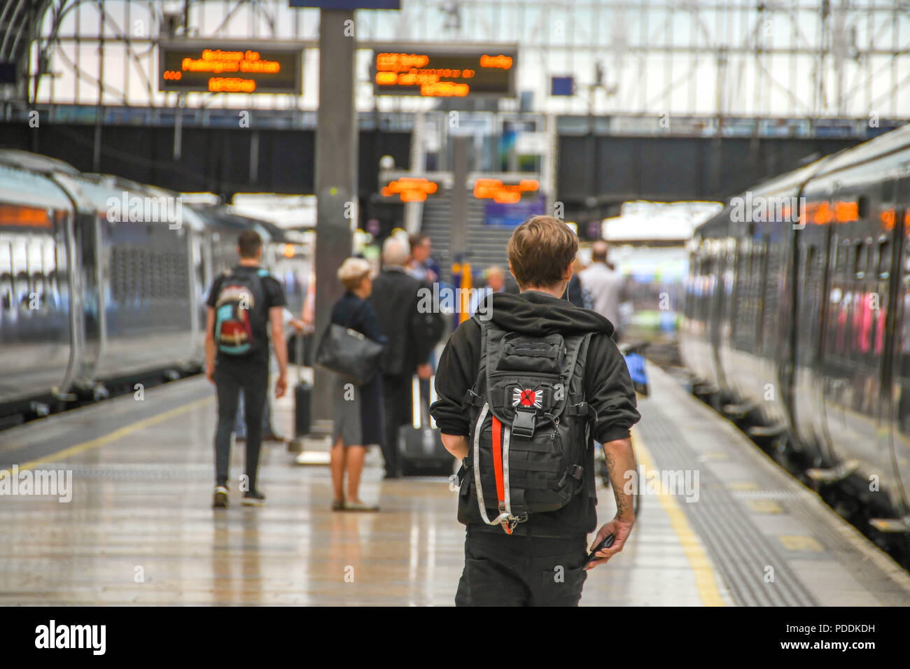 Young person walking along a platform at London Paddington railway ...