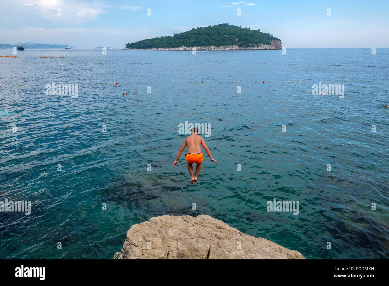 People jumping off a cliff to the Adriatic sea in front of the Lokrum island in Dubrovnik, Croatia, Europe Stock Photo