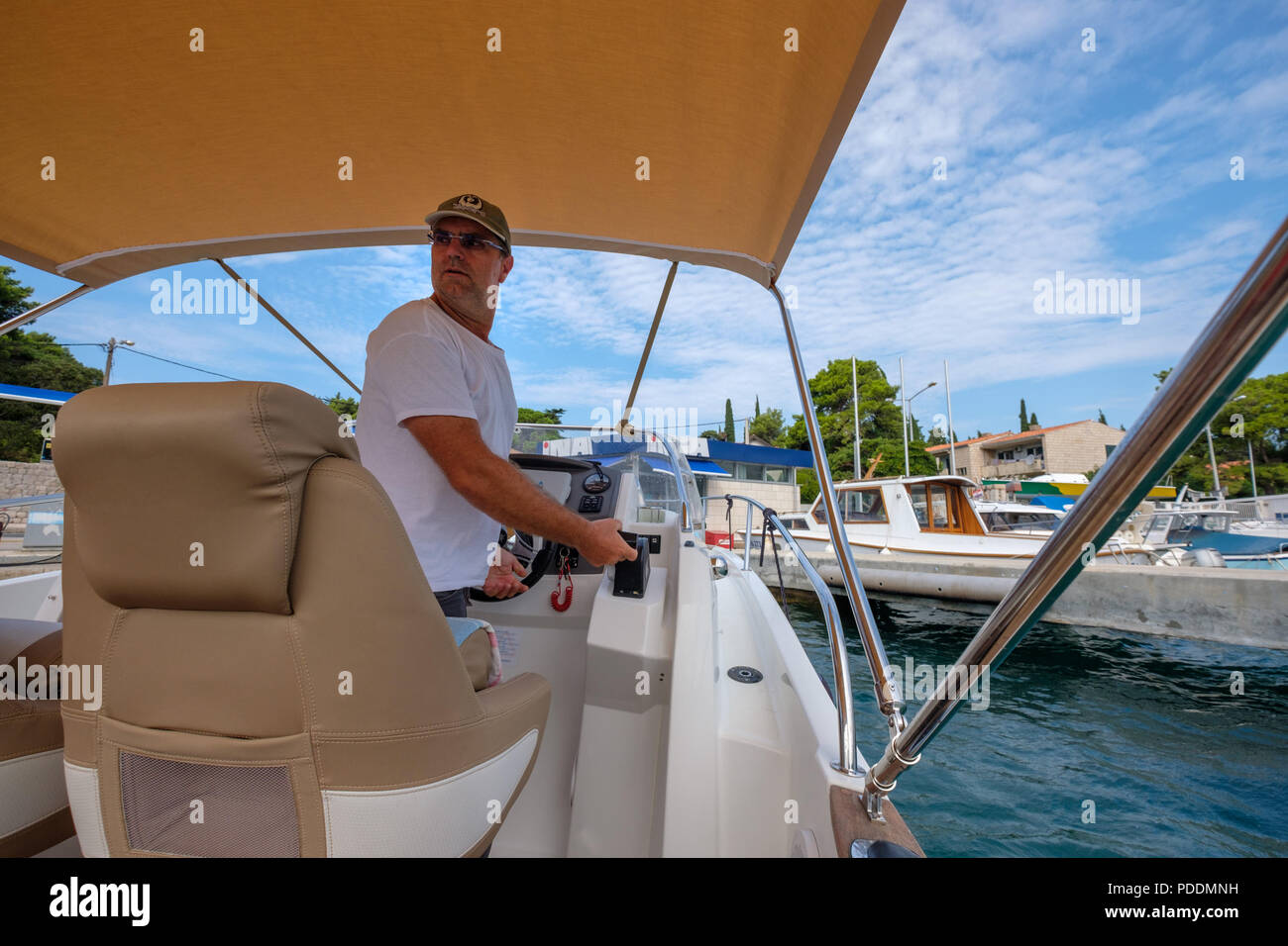 Man looking back while steering a motor boat Stock Photo